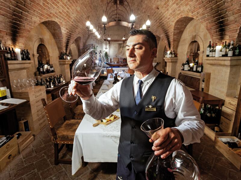 Sommelier sampling wine at Cave de Vinhos.