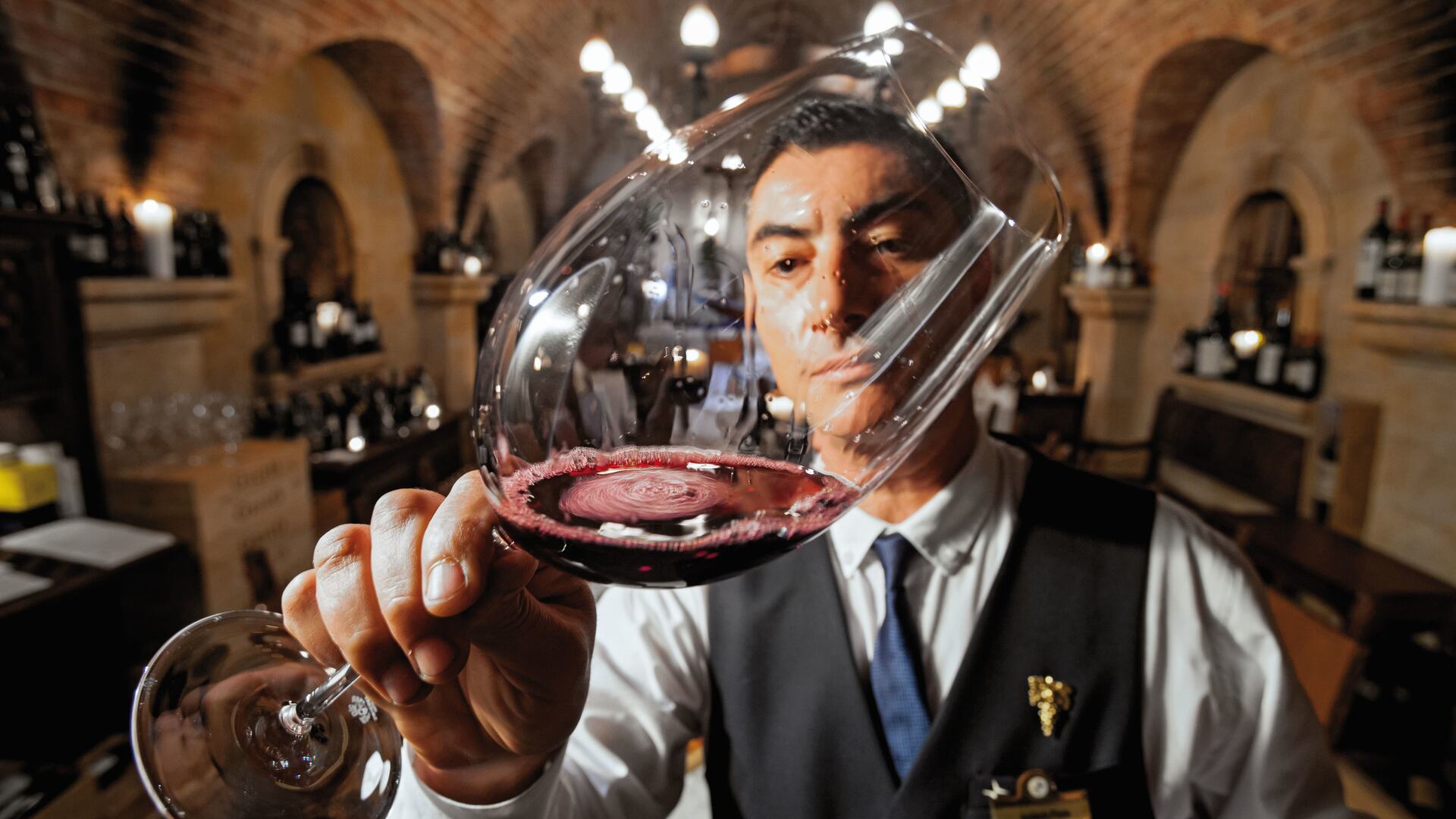 Sommelier sampling wine at Cave de Vinhos