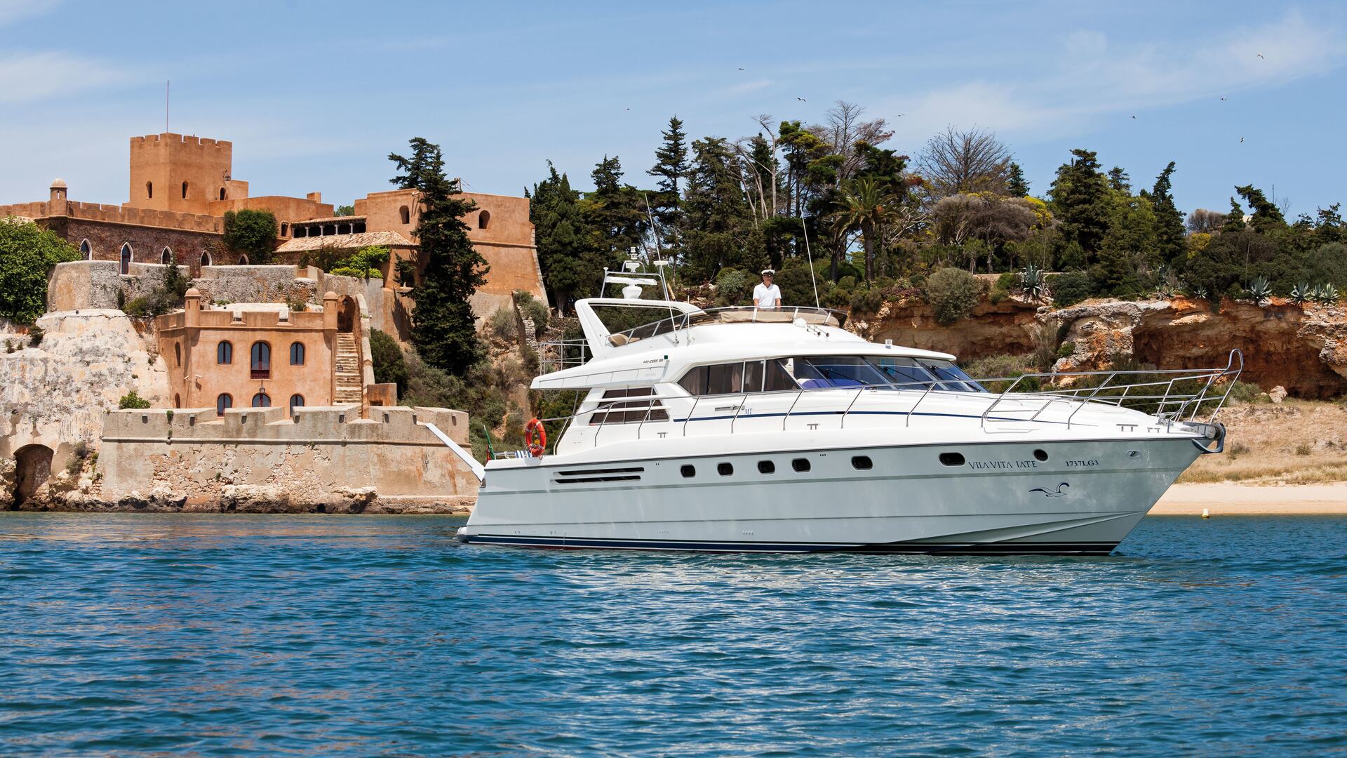 Vila Vita Yacht sailing across Ferragudo's Castle