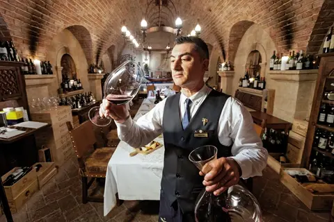 Sommelier sampling wine at Cave de Vinhos.