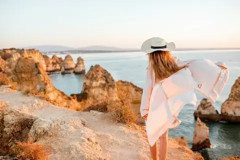 Beyond the resort: Woman walking on Algarve Beach.