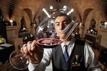 Sommelier sampling wine at Cave de Vinhos