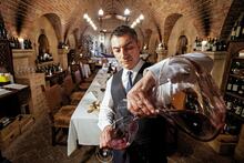 Sommelier sampling wine at Cave de Vinhos