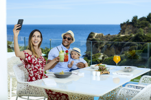 Family enjoying healthy breakfast and taking selfies