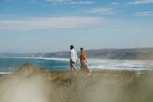 VVP V-Life fashion shoot: Couple walking next to beach.