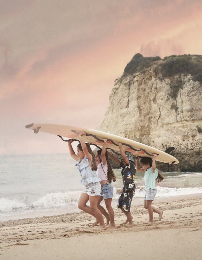 Children on the Tremoços beach with surf board, near Vila Vita Parc